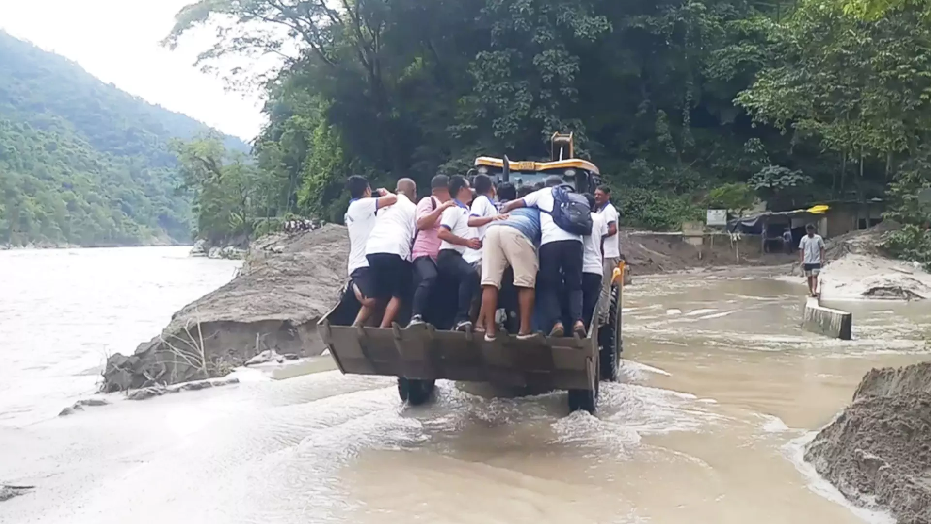 People try to escape a flooded area on a lorry in Kalimpong.