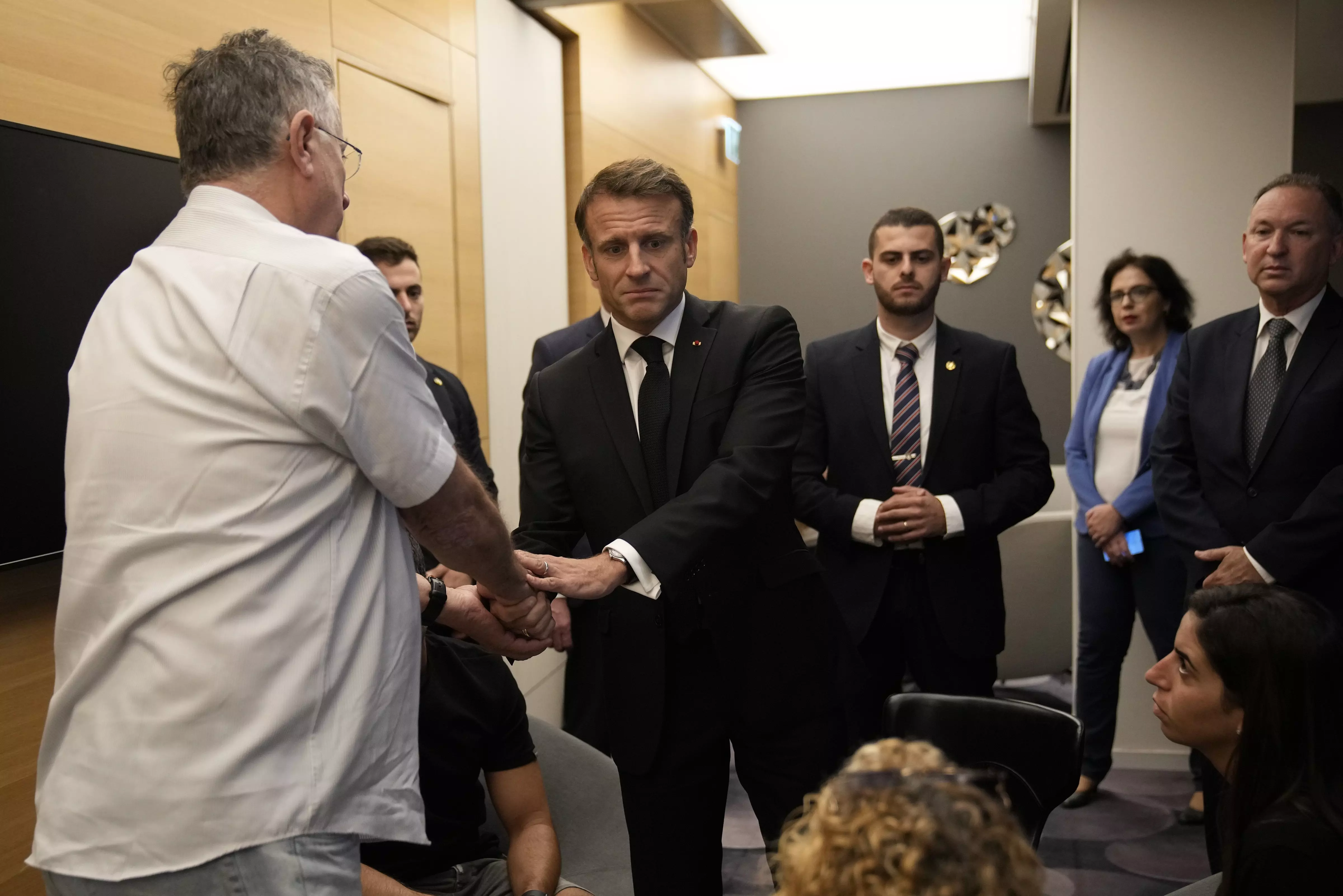 French President Emmanuel Macron (centre) meets with Israeli-French nationals who have lost loved ones, as well as families of hostages, at the Ben Gurion airport, Tuesday, in Tel Aviv. Macron is traveling to Israel to show Frances solidarity with the country and further work on the release of hostages who are being held in Gaza | AP/PTI