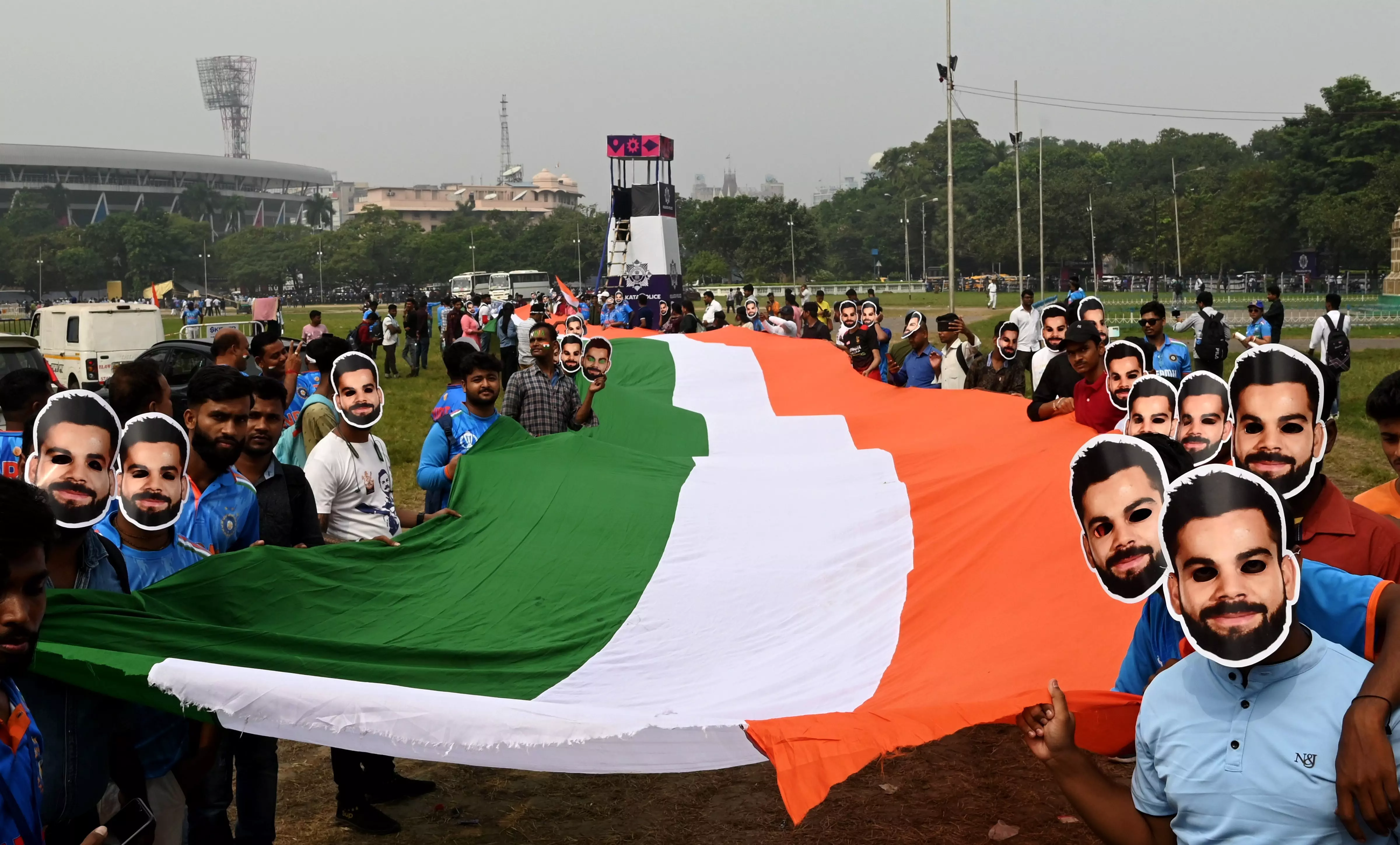 Fans wearing masks of  Virat Kohli carry the Indian tricolour as they prepare to enter the stadium to watch the ICC World Cup 2023 match between India and South Africa, at Eden Gardens, in Kolkata, Sunday, November 5. Photo: PTI