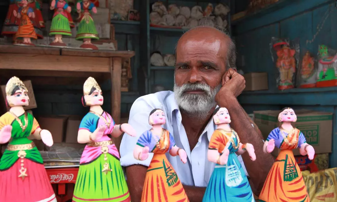 Thanjavur, India -July 31,2102 :An unidentified man sells Tanjore dancing dolls in Thanjavur, India. Dancing dolls of Tanjore are very popular and is widely used in the Navarathri festivals. iStock