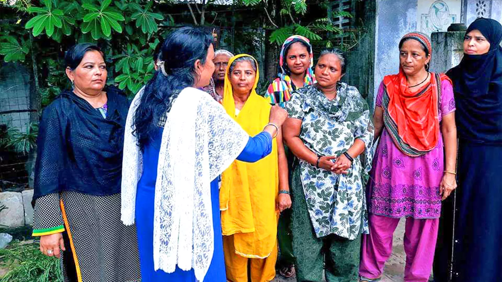 Noorjahan (blue kurta) talks to women survivors in a relief camp in Ahmedabad.