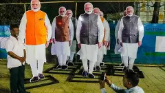 Kolkata: A worker poses for photos with cut-outs of Prime Minister Narendra Modi at Esplanade metro station, in Kolkata