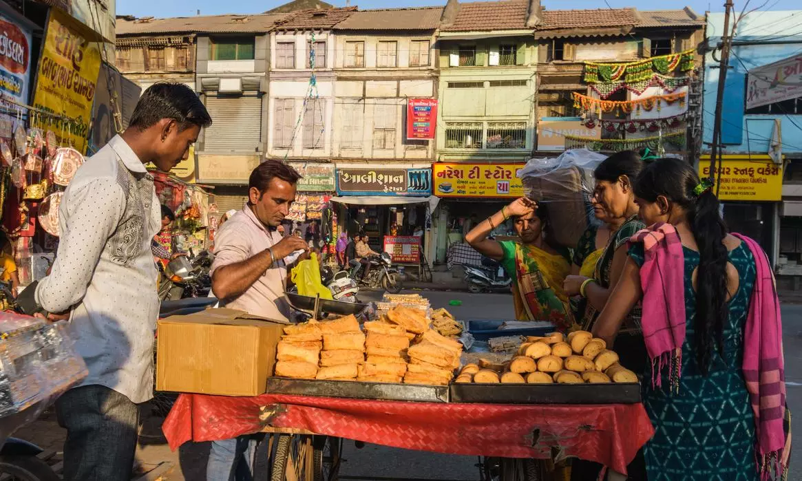 Bhavnagar, Gujarat, India  A   market scene from the old town with a street vendor selling biscuits from his roadside cart