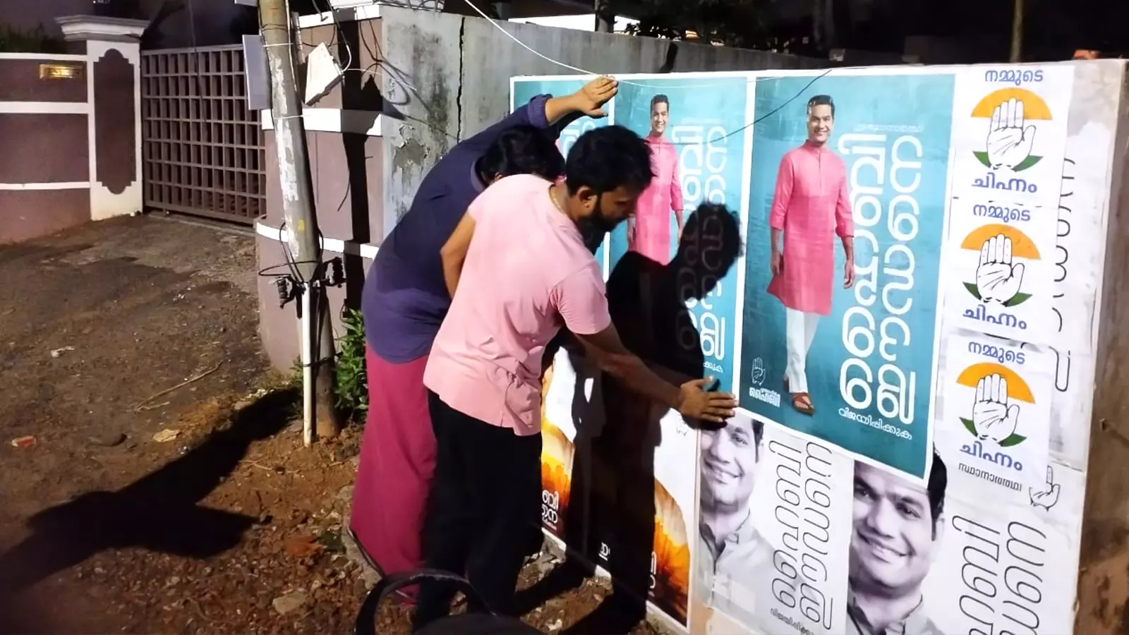 Congress workers sticking posters of Hibi Eden designed by Zainul Abid.
