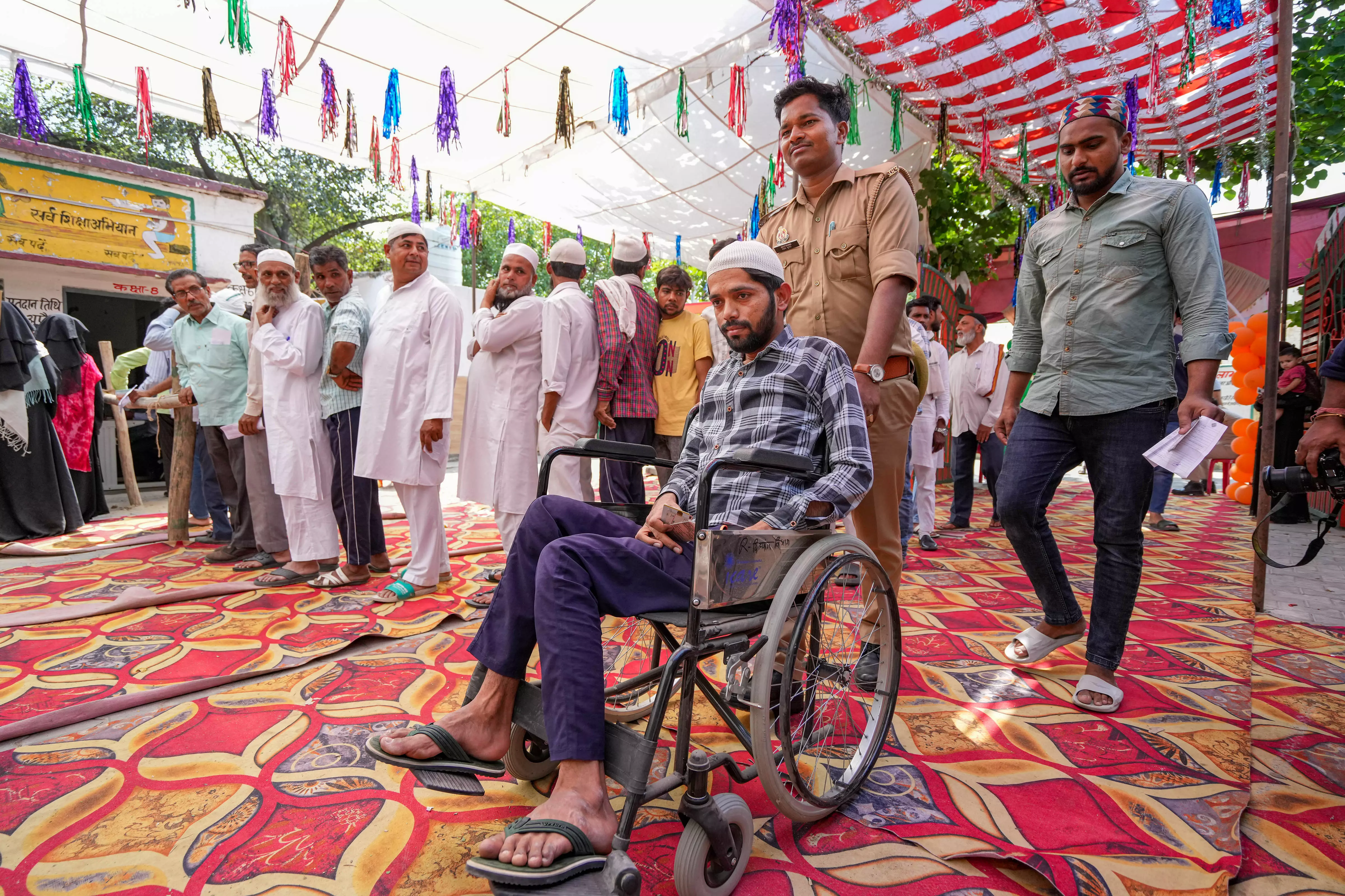 Voters wait in a queue at a polling station to cast their votes for the second phase of Lok Sabha elections at Joya, in Amroha. Photo: PTI   