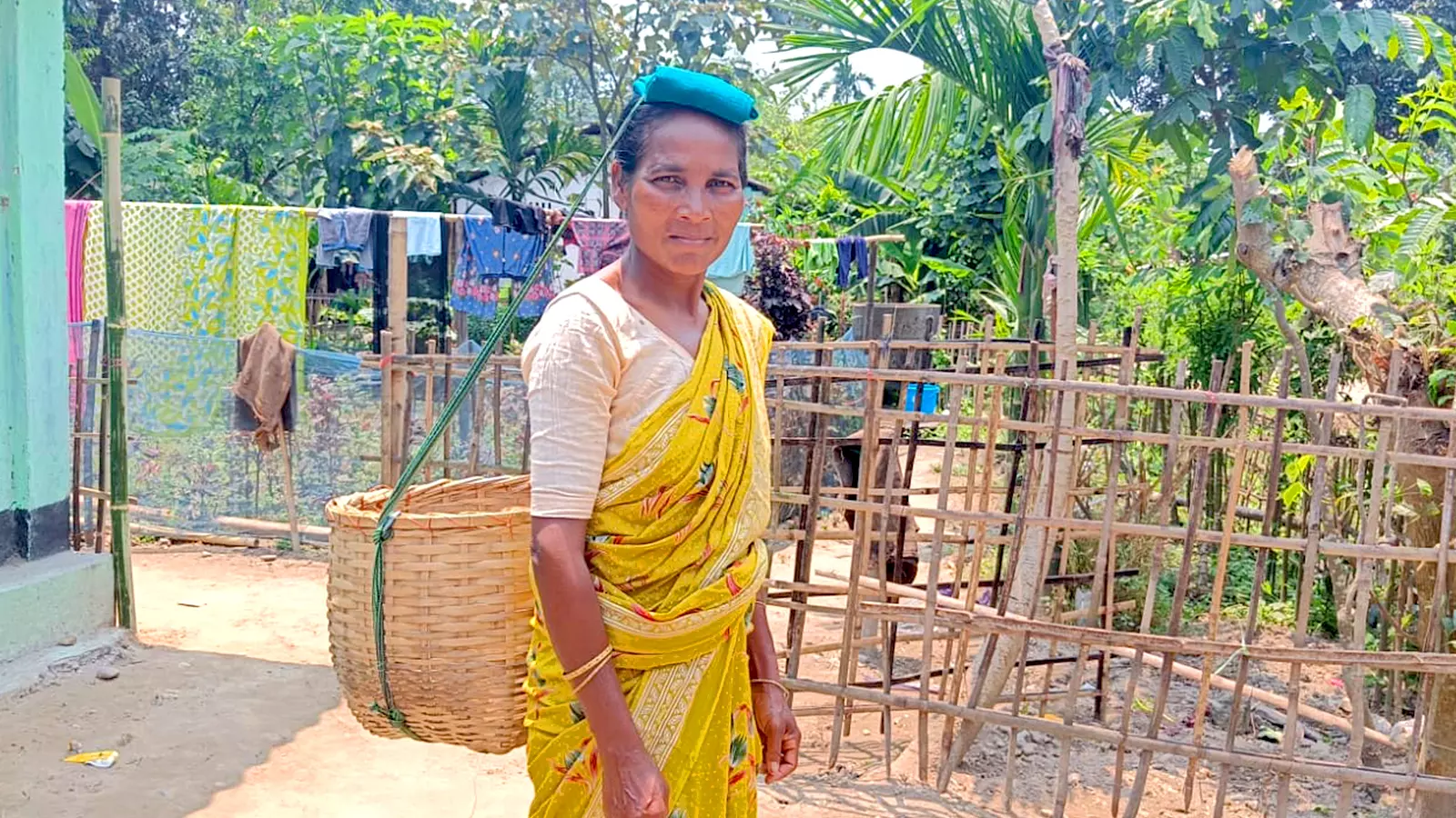 Nirmala Topno poses outside her home in Balijan, a village in Lakhimpur district of Assam.