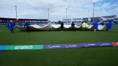 Groundsmen pull the covers off the field before an ICC Mens T20 World Cup cricket match between the United States and Ireland at the Central Broward Regional Park Stadium on Friday