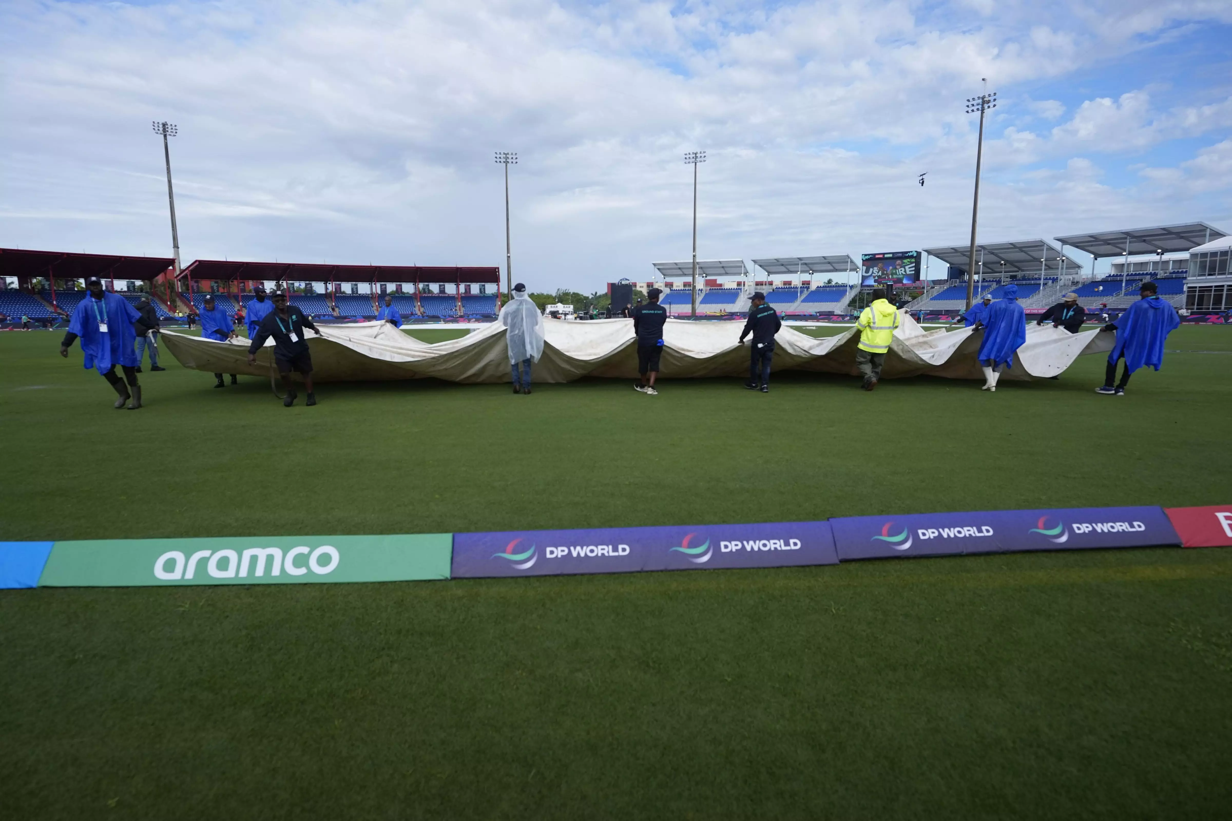 Groundsmen pull the covers off the field before an ICC Mens T20 World Cup cricket match between the United States and Ireland at the Central Broward Regional Park Stadium on Friday