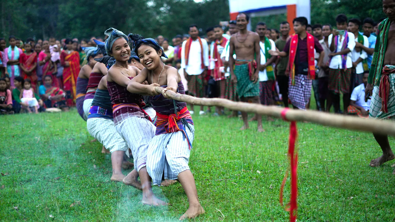 Girls dressed in traditional Rabha attire participate in Leuwa Bokai, a tug of war event where they pull a thick tree vine known as Leuwa instead of a rope.