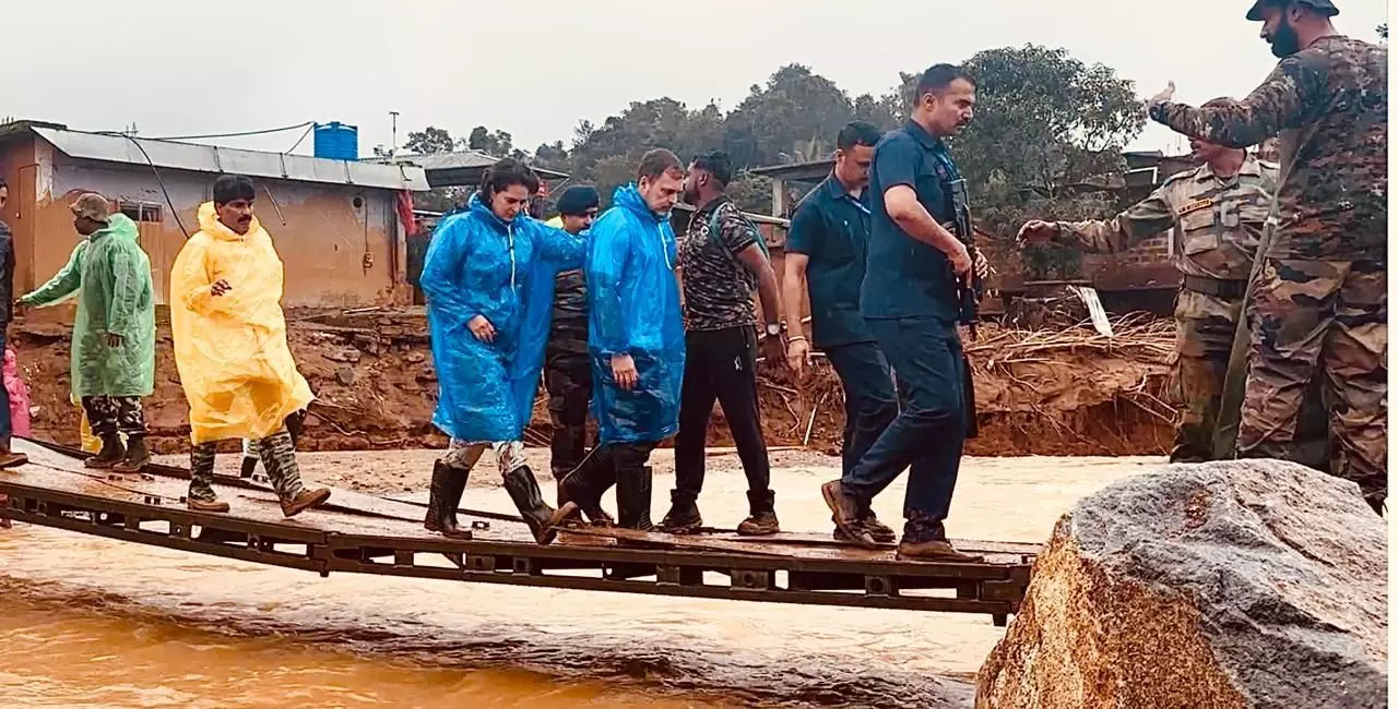 Rahul and Priyanka cross a bridge to reach the landslide spot at Chooralmala 