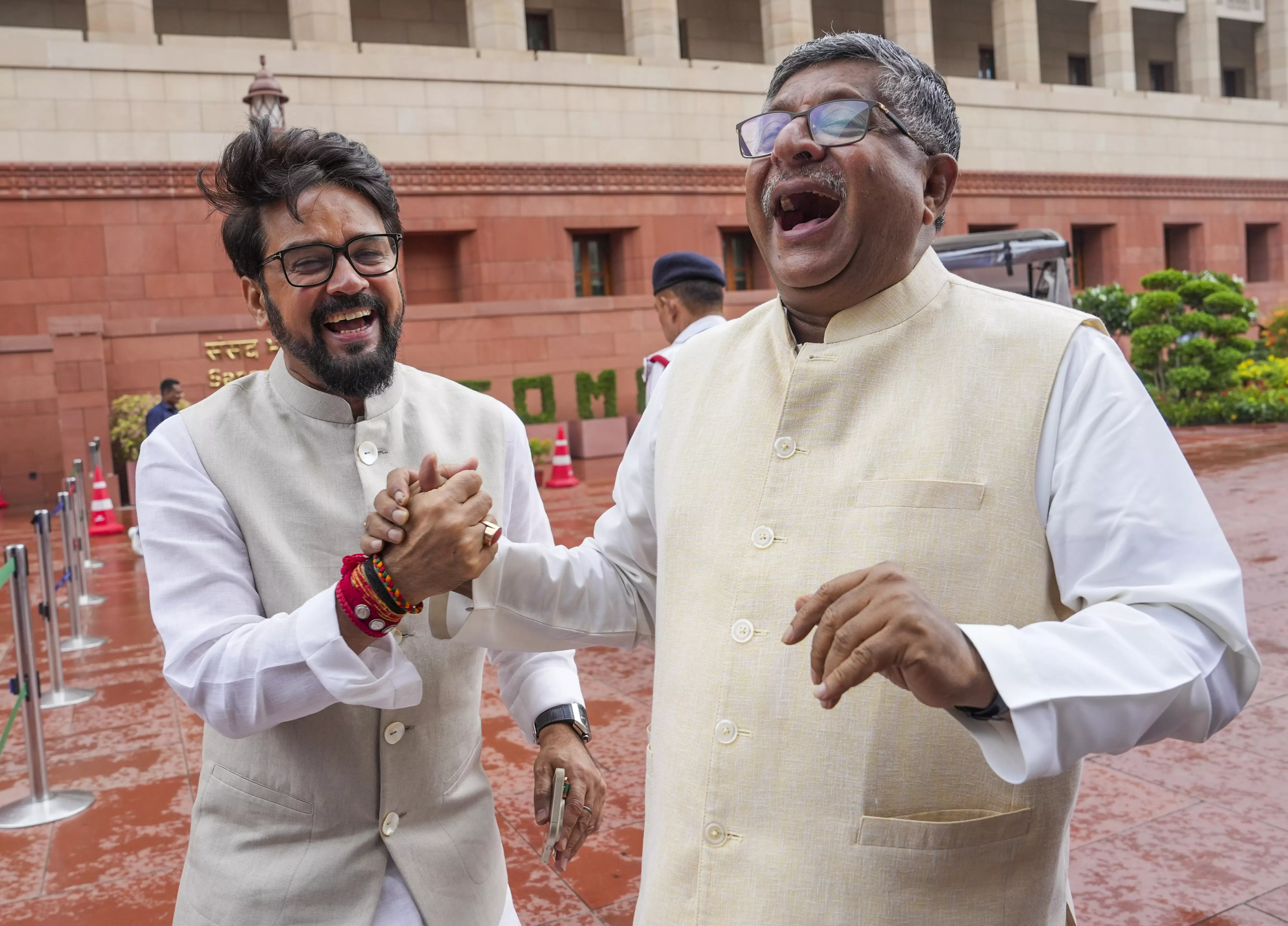 BJP MPs Ravi Shankar Prasad and Anurag Thakur share a lighter moment at the Parliament House complex during the Monsoon session, in New Delhi, Monday, August 5. PTI