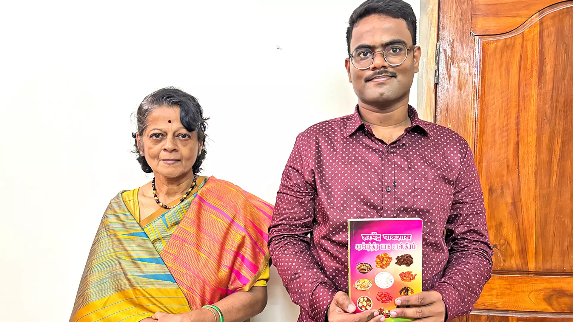 Pratap Sinh Serfoji Raje Bhosale and his mother, Ayshwarya Serfoji Raje Bhosale with the reference cookbook that carries over 100 recipes cooked during Serfoji IIs reign.  