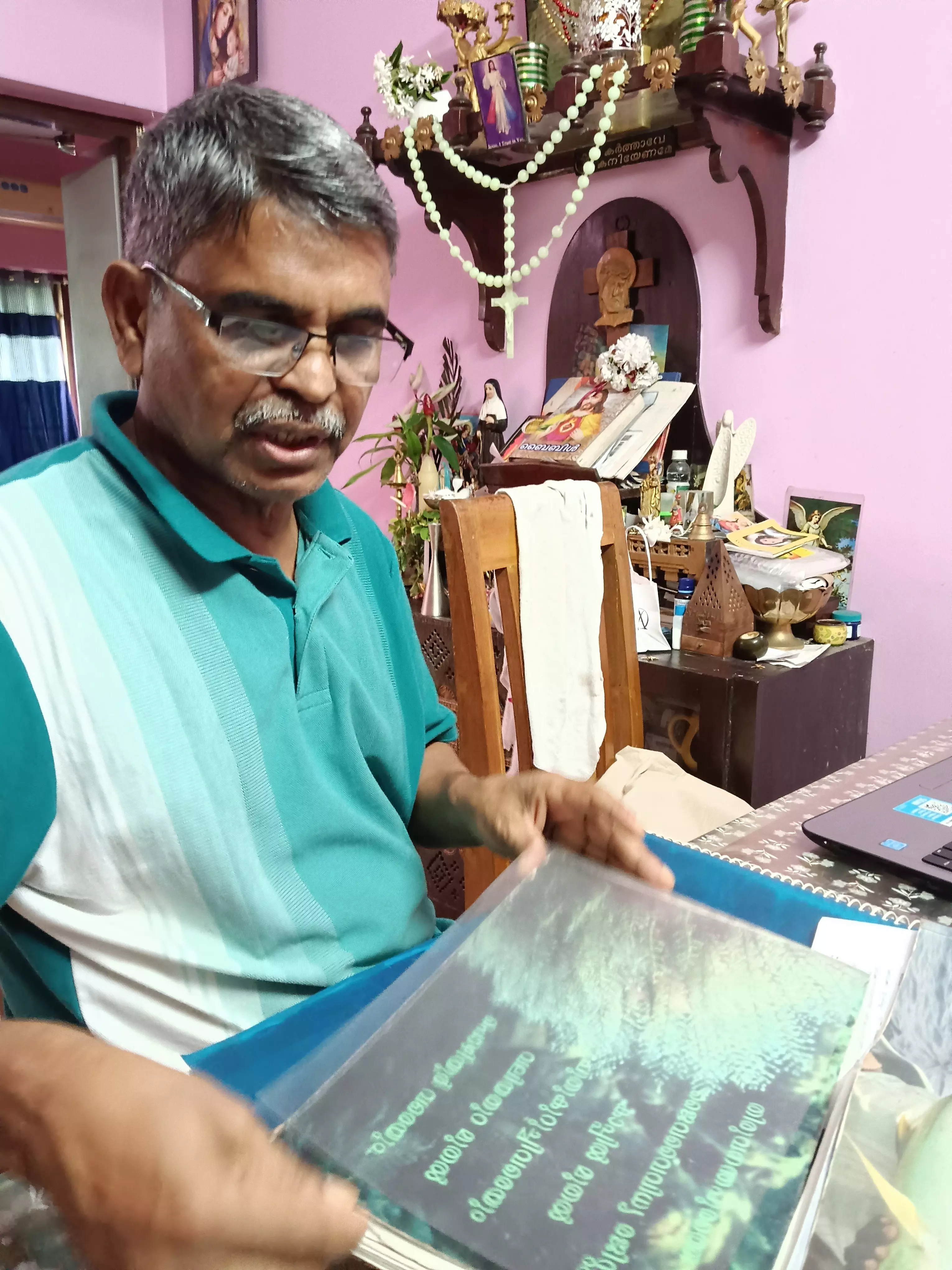 Robert Panipilla with the copies of the two volumes of the report that he submitted in 2015.