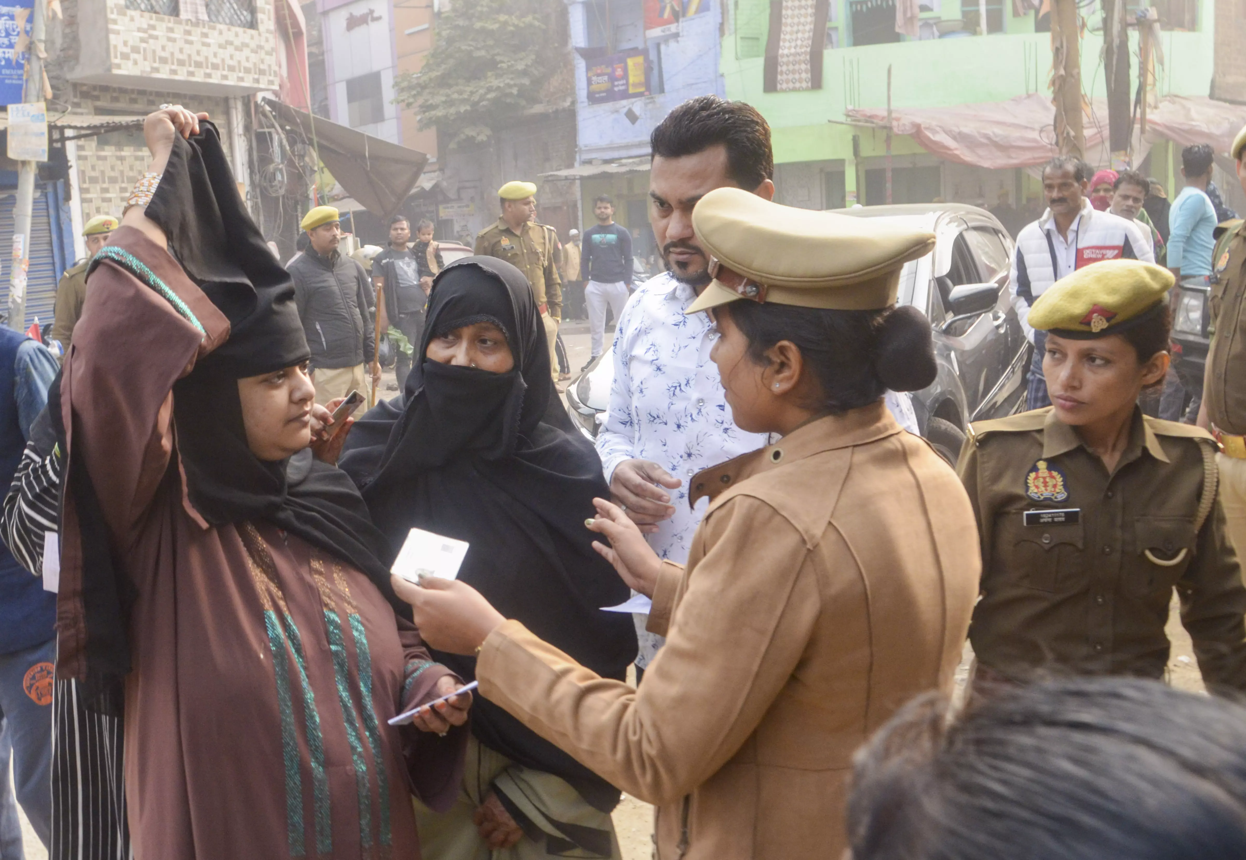 A security official checks a voter during the Sisamau Assembly by-election at a polling booth, in Kanpur district | PTI 