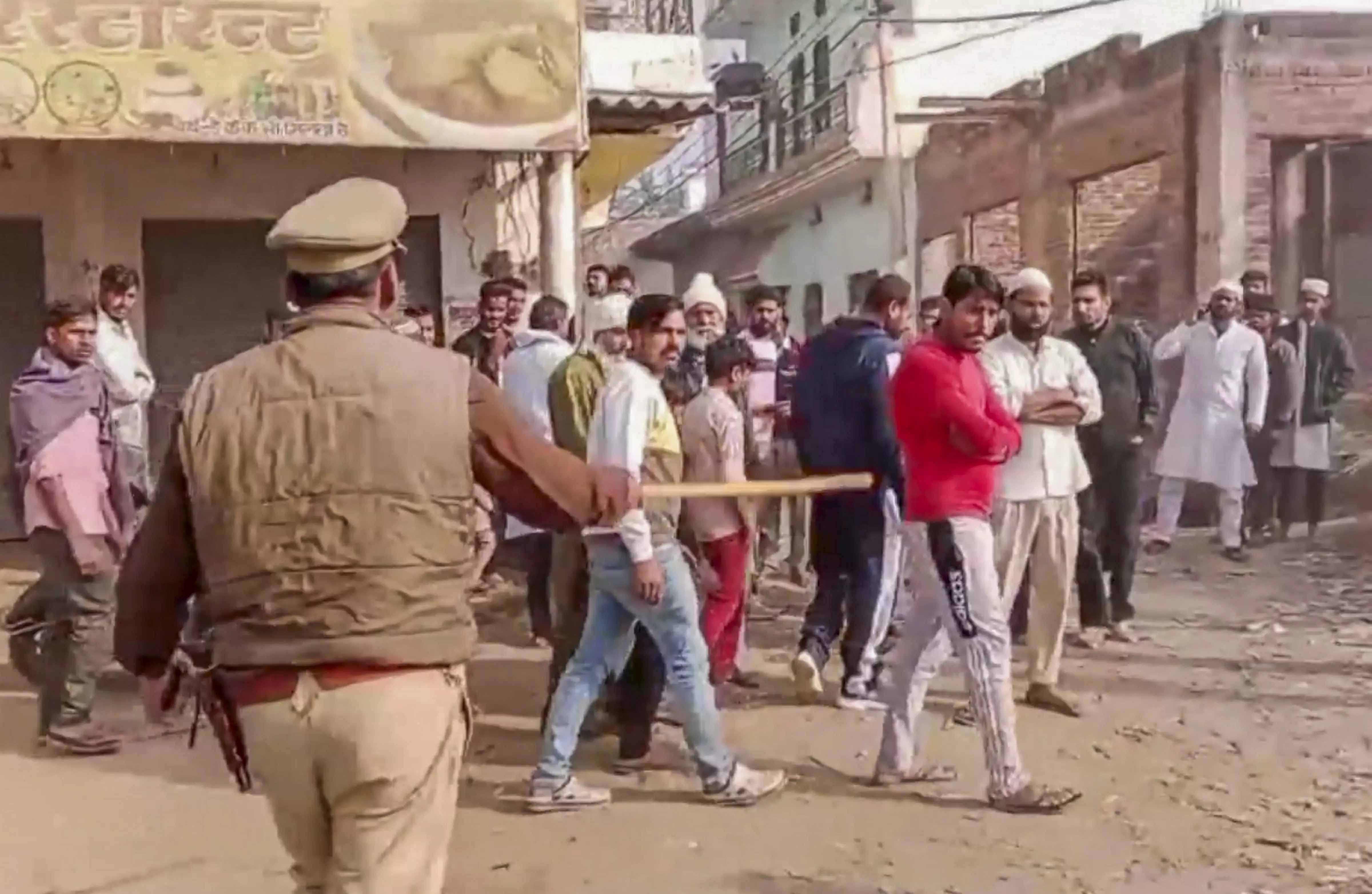 A policeman tries to maintain law and order after an alleged incident of stone pelting during UPs Meerapur Assembly constituency bypoll, in Muzaffarnagar | PTI