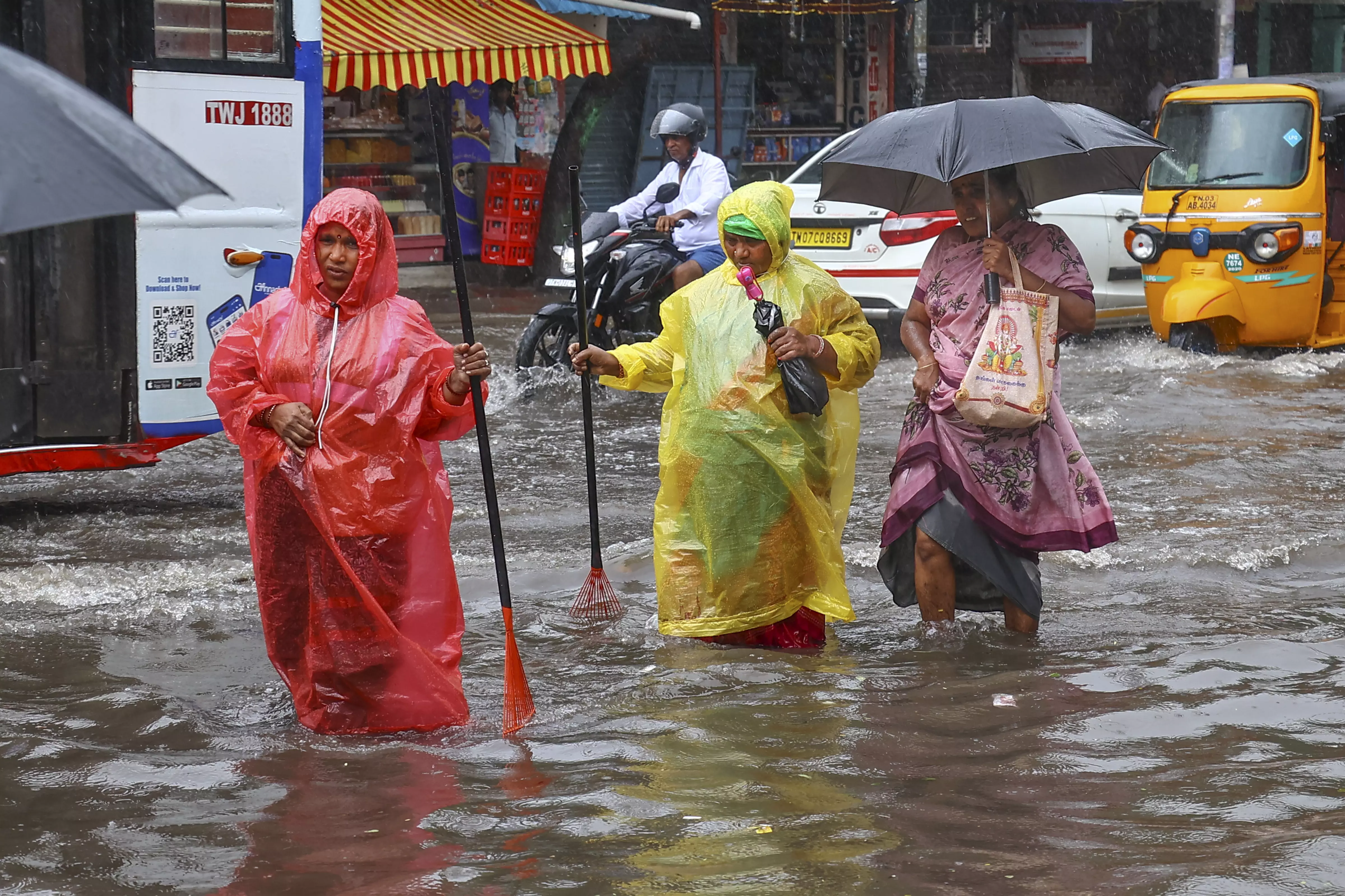 People wade through a waterlogged road amid rain owing to Cyclone Fengal, in Chennai, on Saturday | PTI 