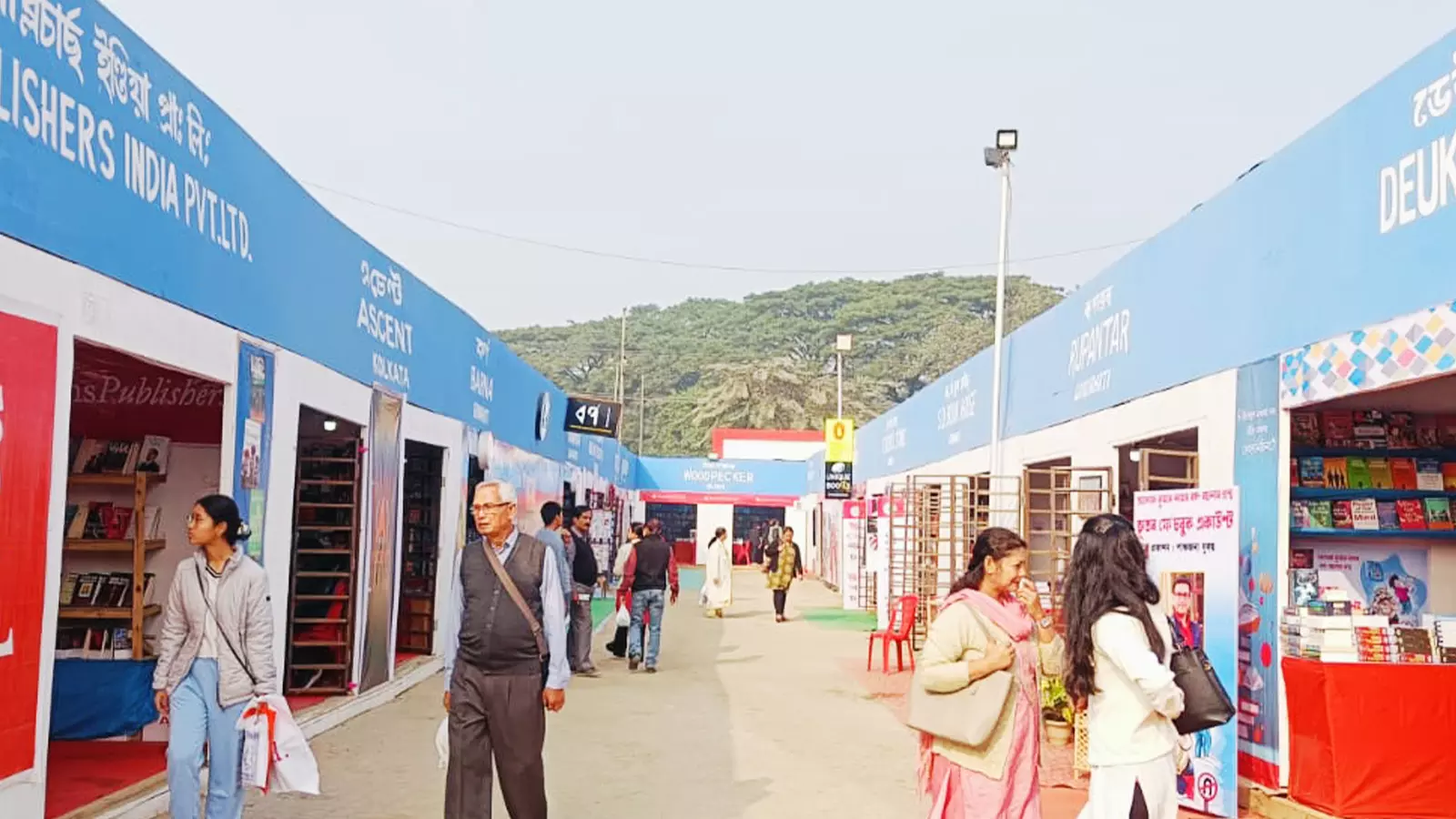  A steady flow of bibliophiles entering and exiting various counters at the fair. 