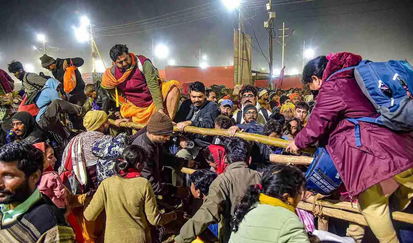 Devotees attempt to cross a barricade at the Maha Kumbh on the say of the stampede. PTI File Photo