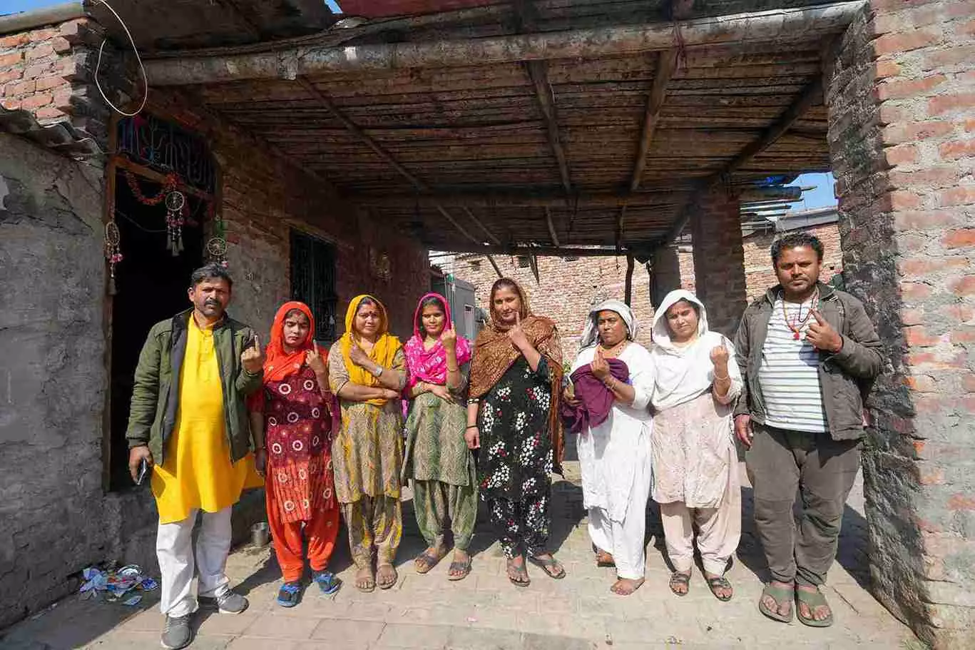 Pakistani Hindu refugees show their fingers marked with indelible ink after casting their votes for the first time during the Delhi Assembly elections, at a resettlement colony in Majnu Ka Tila area, in New Delhi, on Wednesday | PTI