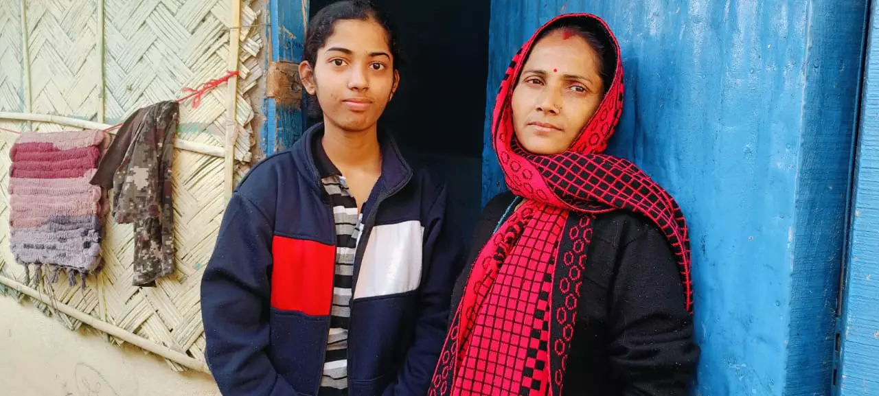 Kushi Basfore (left) poses with her mother, Gunja (right), outside their house.