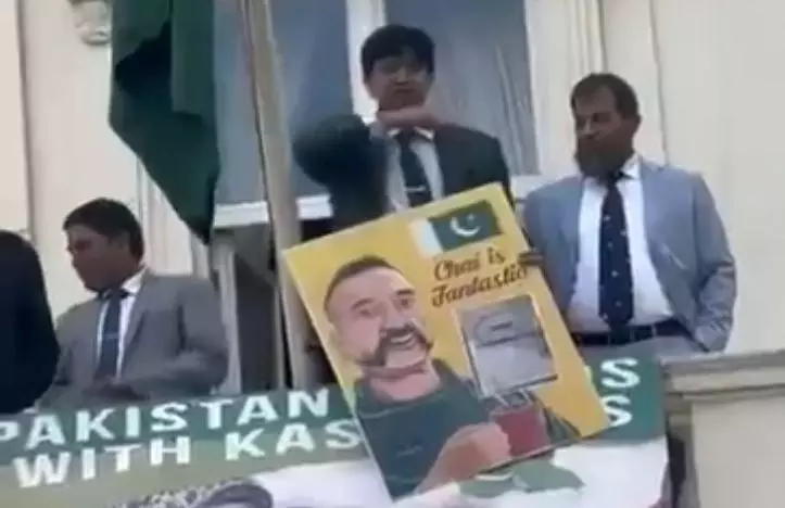 A Pakistani diplomatic official makes a throat-slit gesture