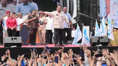 Indonesian President Prabowo Subianto, center, throws his hat to the crowd during a May Day rally at the National Monument in Jakarta, Indonesia, Thursday, May 1, 2025