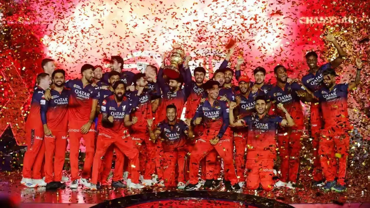 RCB players celebrate with the trophy after winning IPL 2025 final