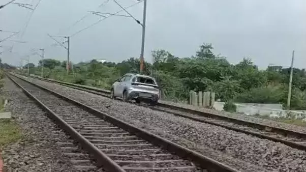 Car being drive on railway tracks