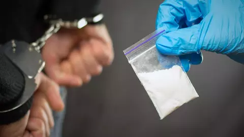 A police officer finds drugs during the search of drug dealers A police officer finds drugs during the search of drug dealers