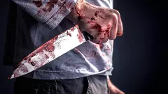 Midsection Of Murderer Holding Blooded Knife Against Black Background