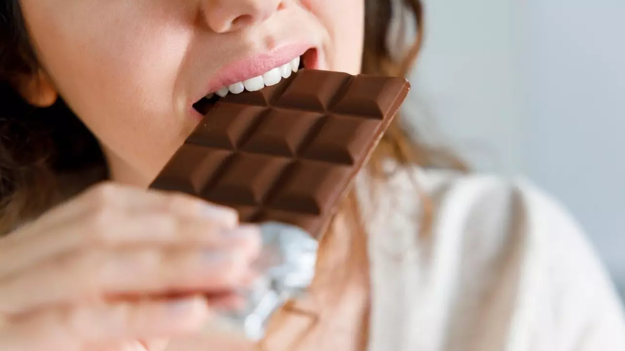 Woman biting a chocolate bar