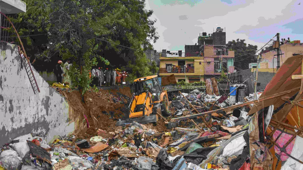 Debris being removed from the site after a wall collapsed amid heavy rains, near Mohan Baba Mandir at Harinagar Debris being removed from the site after a wall collapsed amid heavy rains, near Mohan Baba Mandir at Harinagar