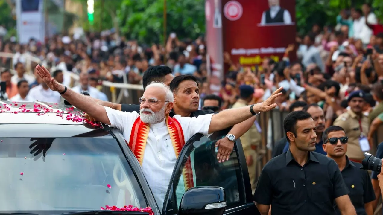 Prime Minister Narendra Modi greets people during a roadshow, in Ahmedabad, Gujarat, on August 25, 2025. (PMO via PTI Photo)