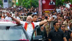 Prime Minister Narendra Modi greets people during a roadshow, in Ahmedabad, Gujarat, on August 25, 2025. (PMO via PTI Photo)
