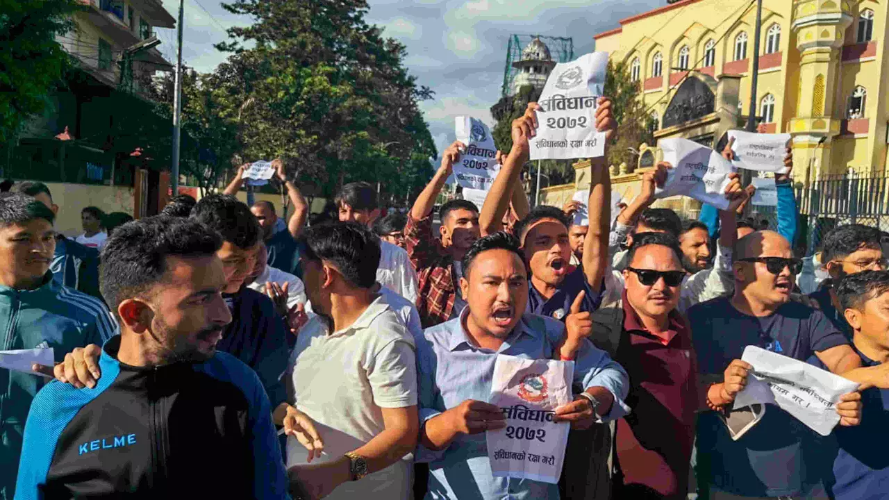 Demonstrators hold placards and raise slogans during a protest in Kathmandu