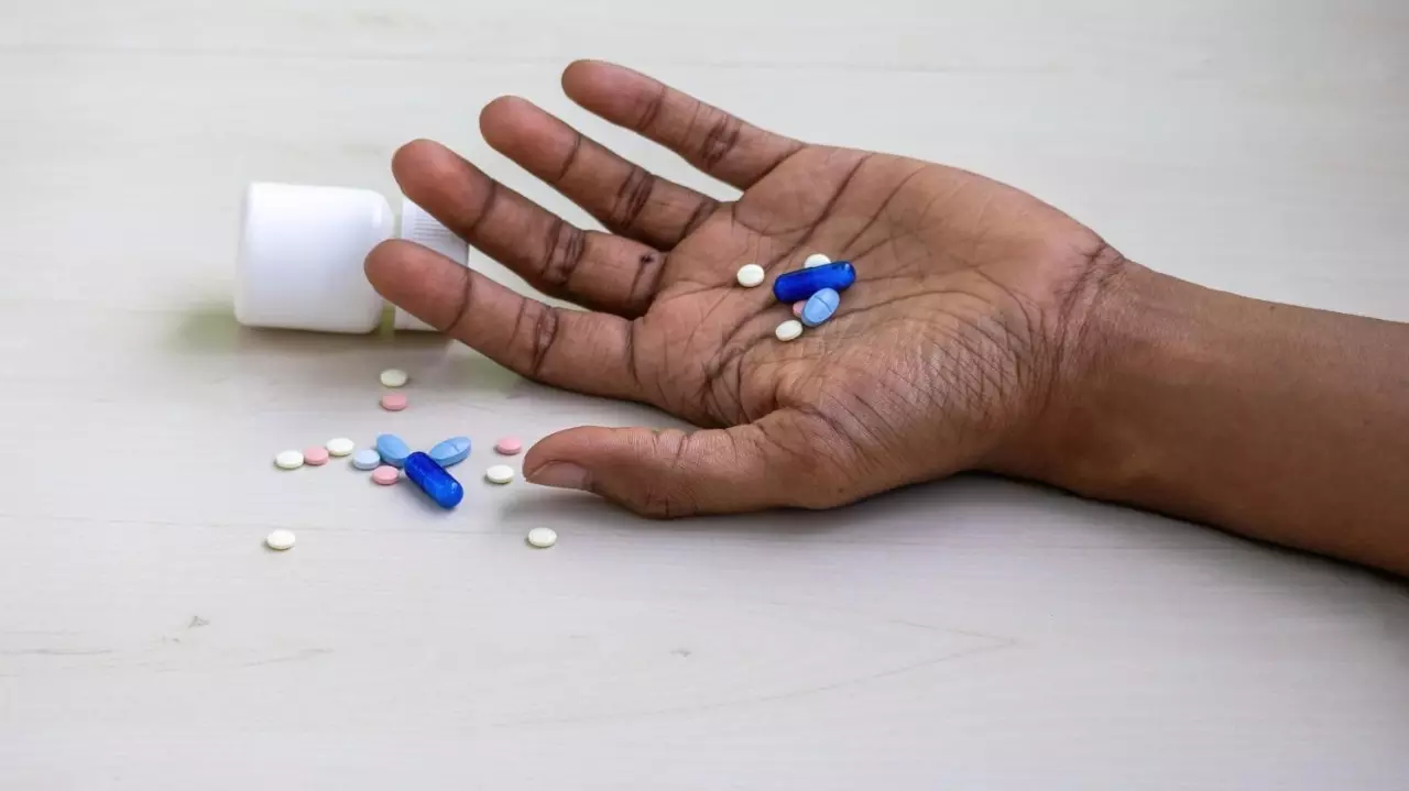 Mans hand with various tablets and pills