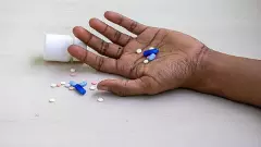Mans hand with various tablets and pills