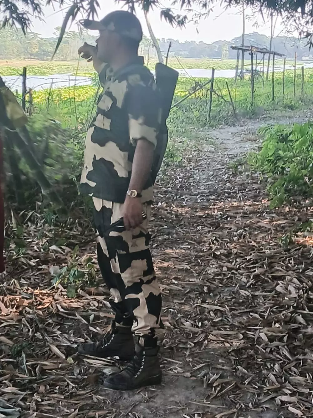A BSF officer points towards the Shonai River which acts as the border here and is one of the alleged routes for illegal migration and smuggling. Photo: The Federal