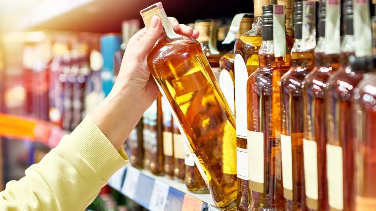 Bottle of whiskey in hand stock photo