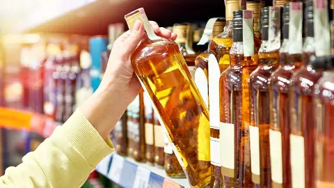 Bottle of whiskey in hand stock photo
