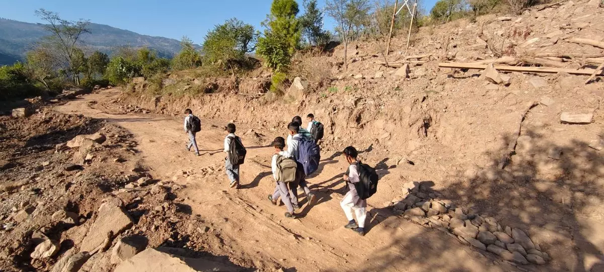 Children make their way to school through a deserted part of Tirshi, following the landslide. Photo: Bivek Mathur
