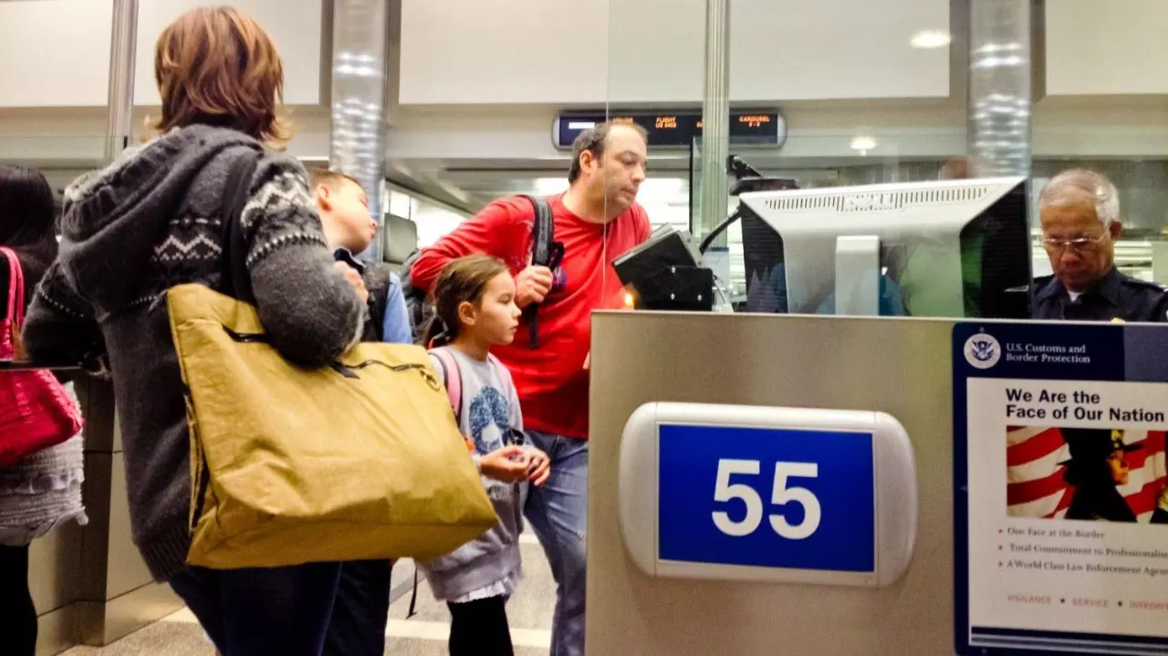 US Immigration officer checking documents of tourists stock photo