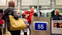 US Immigration officer checking documents of tourists stock photo