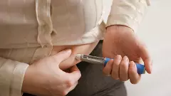 Woman using Semaglutide injection pen stock photo