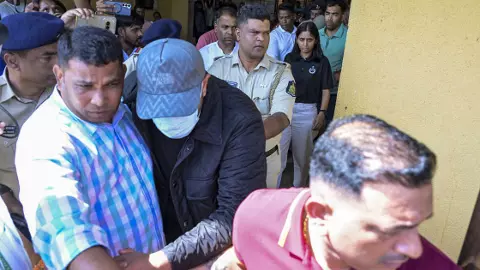 One of the Luthra brothers being escorted by police