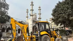 A bulldozer stands next to Faiz-e-Elahi Masjid in Old Delhi. A bulldozer stands next to Faiz-e-Elahi Masjid in Old Delhi.