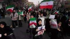 People carry Iranian flags and pro-government placards during a funeral ceremony for a group of security forces, who were killed during anti-government protests in Iran