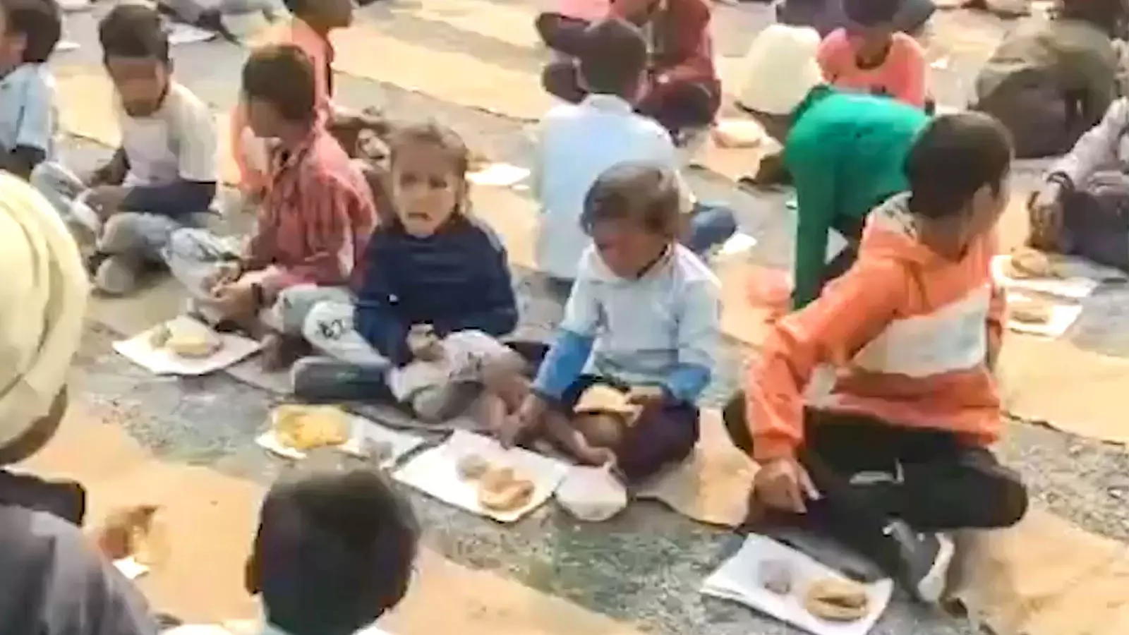 Videos circulating on social media show students seated on the ground in the school courtyard with no plates visible Videos circulating on social media show students seated on the ground in the school courtyard with no plates visible