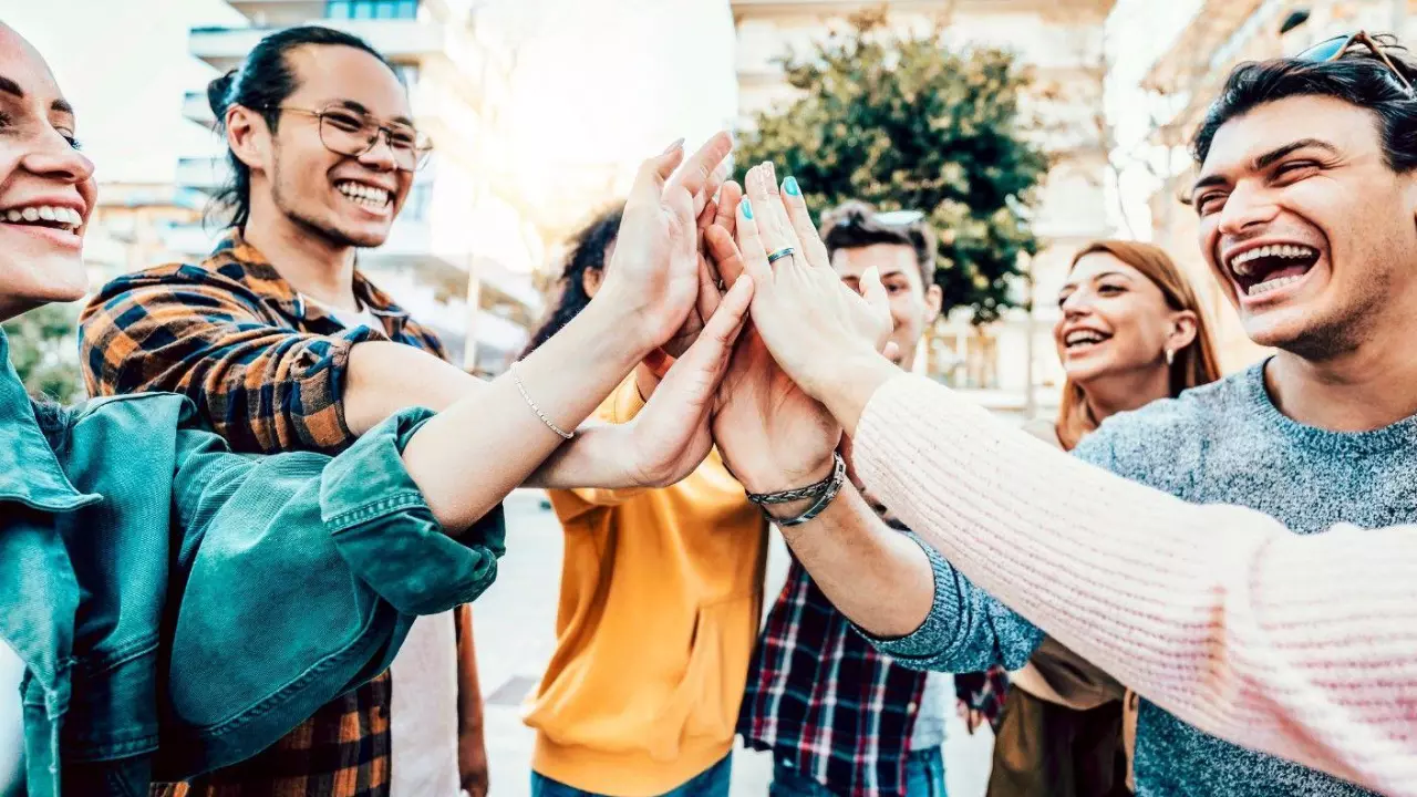 oung smiling team people stacking hands stock photo