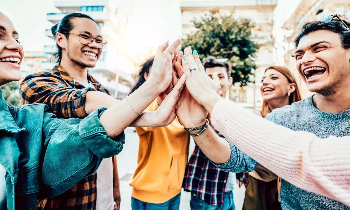 oung smiling team people stacking hands stock photo oung smiling team people stacking hands stock photo